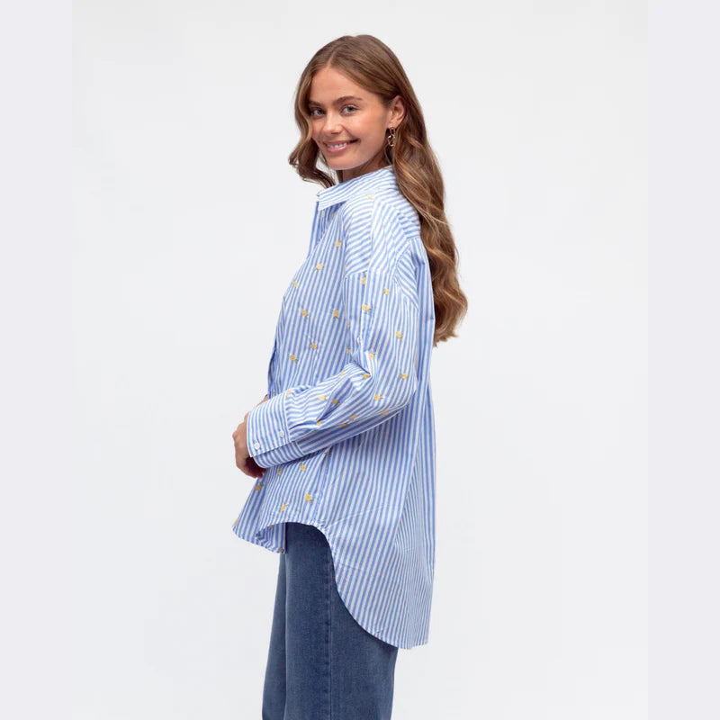 Woman wearing a blue and white striped shirt with a plain background