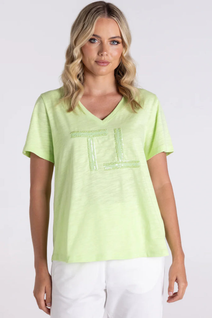 Woman wearing a light green t-shirt with a logo on a white background
