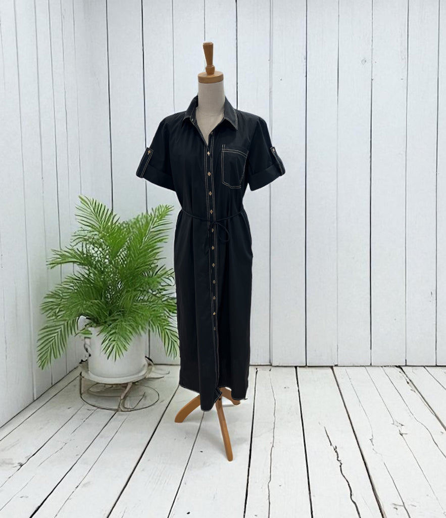 Black dress on a mannequin against a white wooden panel background
