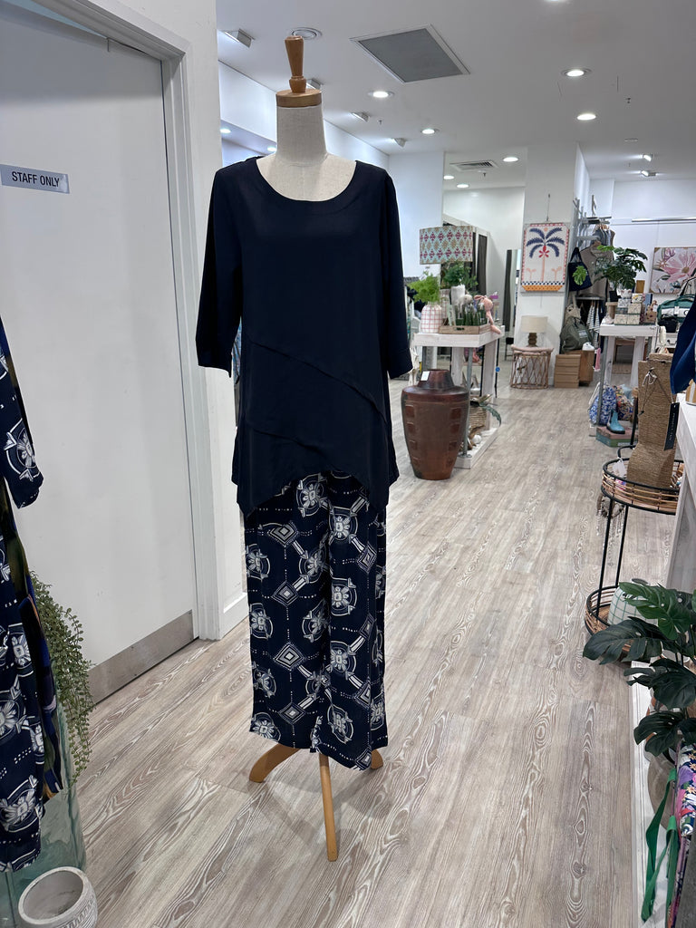The A-line silhouette is enhanced by angled panel detailing, while the asymmetric crossover hemline adds a unique touch. Perfect for any occasion, this top combines elegance with ease. 
