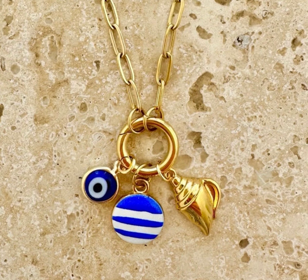 Mosk Melbourne Mediterranean charm necklace in gold on travertine