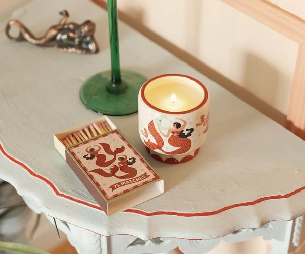 Paddywax ceramic candle pot lit on a side table