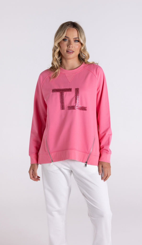 Woman wearing a pink sweatshirt with a logo on a white background
